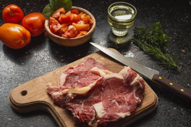 İçinde domates salatası, biberiye ve maydanoz ve yağ var.