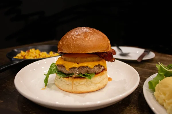 Hawajski Burger Białym Talerzu Drewnianym Stole Czarnym Tle Restauracji — Zdjęcie stockowe