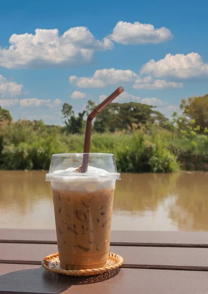 Güneşli bir günde, beyaz süt köpüklü buzlu kahve.