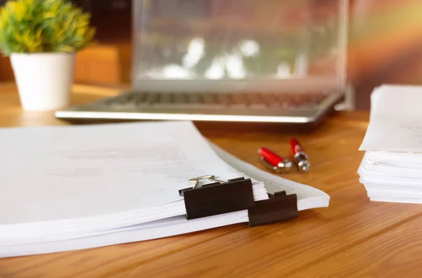 办公室里的木制桌子上放有黑色回形针和办公用品的纸制品 — 图库照片