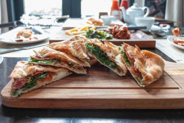 Çıtır jambon üçgen şeklinde pizza. Masadaki tahta tabakta.