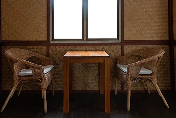 rattan table and chair set nearby window in house