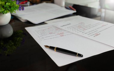 Düzeltme bürosunda ofis malzemeleriyle birlikte kağıt üzerine dolmakalem.
