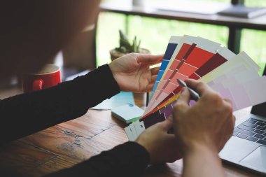 Renk örnekleriyle çalışan yaratıcı tasarımcı görüntüleme ekibini kapat.