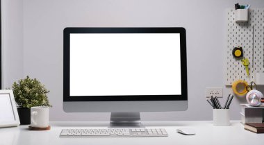 Front view computer with empty display and coffee cup on white table.	
