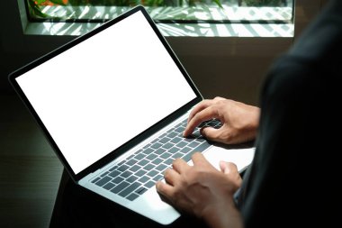 Yakın plan genç adam oturma odasında oturuyor ve bilgisayar laptopu kullanıyor..
