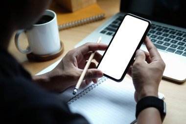Close up view man holding mock up smart phone with white screen.	