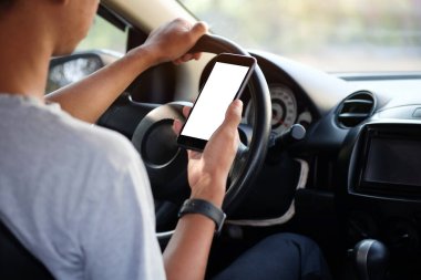 Kesilmiş görüntü. Şoför araba kullanırken telefonu kullanıyor. Yuvarlak kenarlı modern akıllı telefon. Model için izole ekran. Arka planda araba navigasyon görüntüsü.