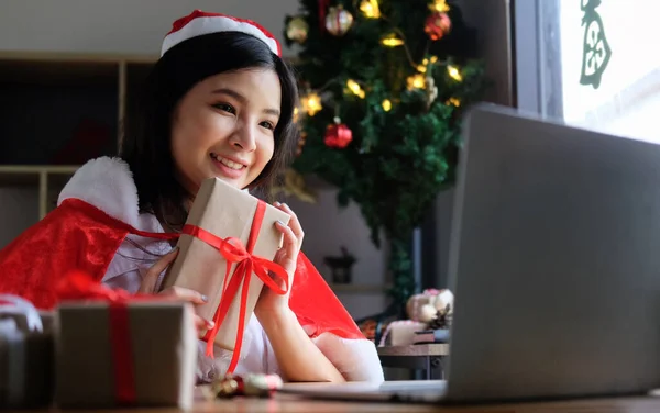 年轻的亚洲微笑的女人拿着礼品盒 与家人进行视频通话 — 图库照片