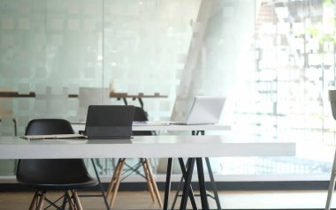 Modern office with laptop computer and supplies on white desk.	
