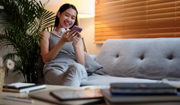 Woman Hold Smart Phone Sit Sofa Use Phone Happily Home — Stockfoto