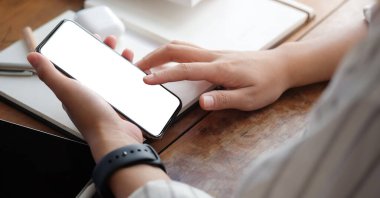 Metin mesajınız veya bilgi içeriğiniz için boş ekranlı akıllı telefonu tutan erkek eli görüntüsü, şehir ortamında cep telefonundan mesaj okuyan kadın görüntüsü.