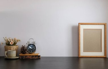 Ev bitkisi, kamera ve kahve fincanı ile beyaz masa ve tuğla duvarlı şık çalışma alanı.