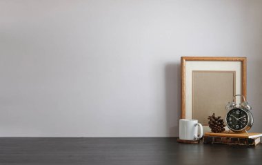 Ev bitkisi, kamera ve kahve fincanı ile beyaz masa ve tuğla duvarlı şık çalışma alanı.