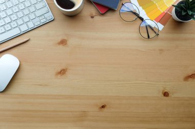 Top view female workspace with glasses, coffee cup, earphone and stationery on wooden table.	