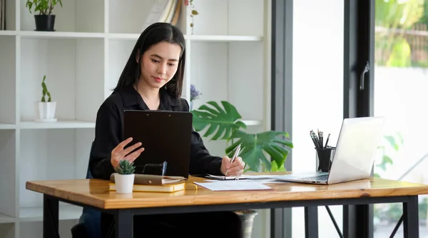 魅力的な若い女性起業家は デジタルタブレットを保持し ラップトップコンピュータと協力 — ストック写真