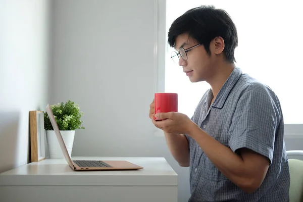 Young Asian Man Casual Pajamas Drinking Coffee Using Laptop Computer — Stock Photo, Image