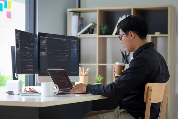 Modern ofiste çalışan Asyalı programcı. Programlama geliştiriliyor.