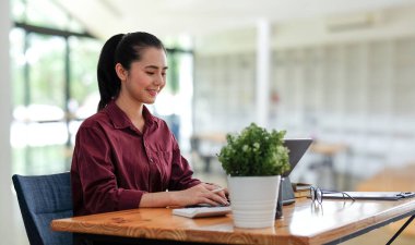 A businesswoman working on new project with laptop computer in modern office.	