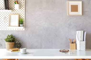 İçişleri Bakanlığı. Çiçek, kahve fincanı, kitaplar ve kalem tutacağı beyaz masada..