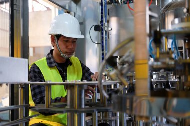 Profesyonel mühendis fabrikada üretim hattındaki makinelerin denetim ve kontrol sürecinde..