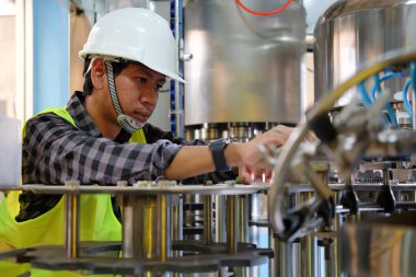 Fabrika endüstrisinde çalışan kasklı teknisyen.