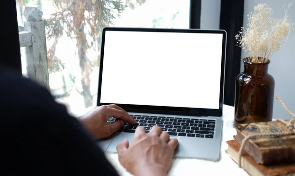 Genç adam evde dizüstü bilgisayarla çalışıyor..