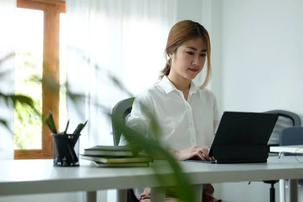 快適な職場に座って コンピュータのラップトップを使用して魅力的なアジアのビジネス女性 — ストック写真