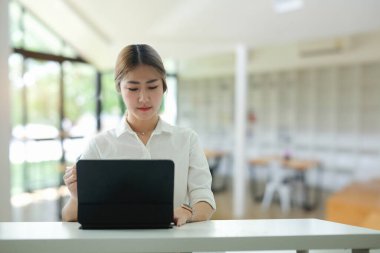 Cheerful businesswoman working with computer laptop at office.	