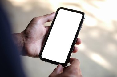 Young man holding mockup smart phone with empty screen. Close up.	