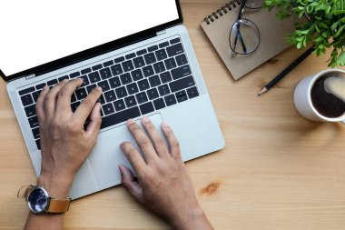 İş adamlarının elleri ahşap masada dizüstü bilgisayar kullanıyor..