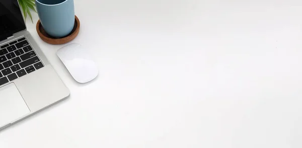 Üst görünüm dizüstü bilgisayar, kablosuz fare ve beyaz ofis masasında fotokopi alanı olan kahve fincanı..