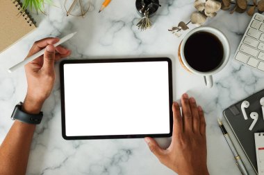 Stylus kalem tutan yaratıcı adam mermer masa üzerinde dijital tabletle çalışıyor..