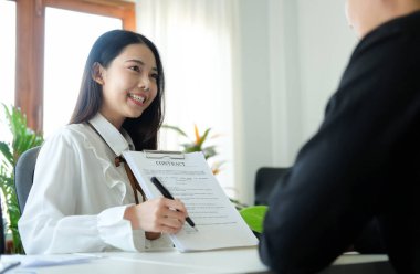 Kendine güvenen emlakçı kadın müşterisine ev sahipliği teklif ediyor..