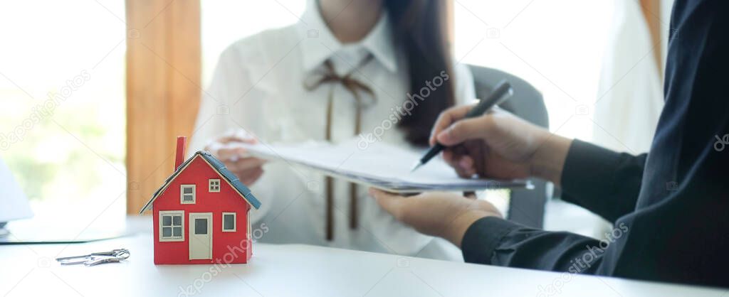 Cropped shot young man signing rental contract with real estate agent . Mortgage and loan ownership concept.