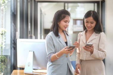 İki genç iş arkadaşı ofiste proje planlamasını tartışıyor..