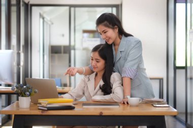 Modern ofiste fikir alışverişinde bulunan iki iş arkadaşı veya yeni iş planı.
