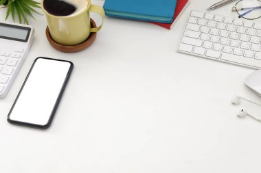 Akıllı telefon, hesap makinesi, kahve fincanı ve beyaz ofis masasında kablosuz kulaklık..