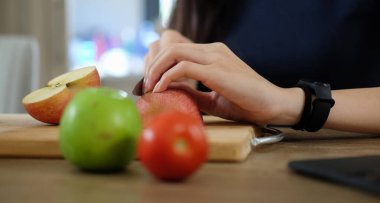 Tahtada elma kesen kadın, mutfakta meyve salatası hazırlayan kadın..