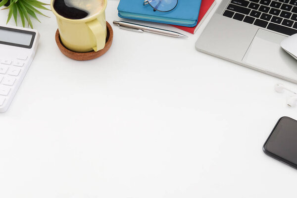 Computer laptop, calculator, coffee cup and smart phone on white table, Top view.