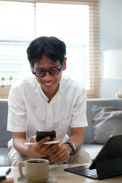 Приємний Азіатський Чоловік Сидить Дивані Використовує Смартфон Спілкування Соціальній Мережі — стокове фото