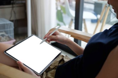 Dijital tablet ekranında stilus kalem yazan sıradan bir genç kadın..