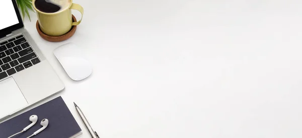 Bilgisayarlı beyaz ofis masası, kablosuz fare, kahve fincanı ve defter..
