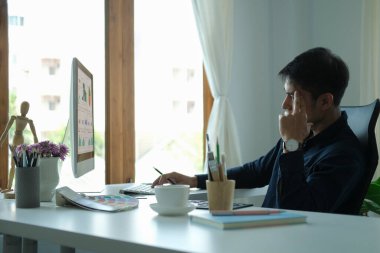 Laptop bilgisayarında finansal verileri analiz eden genç iş adamına odaklan.