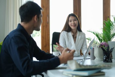 Genç bayan tasarımcı iş ortağına proje hakkında yeni fikirler veriyor..