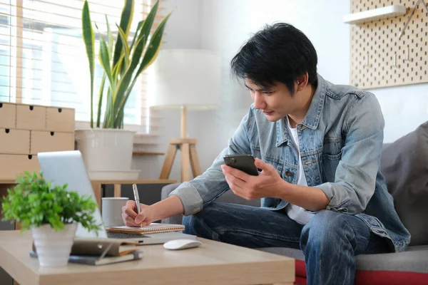 Випадковий Азіатський Чоловік Використовує Мобільний Телефон Під Час Роботи Вдома — стокове фото