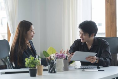 Modern ofiste oturup proje stratejisini tartışan iki genç iş adamı..