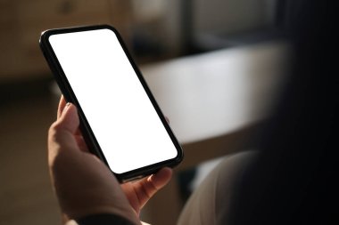 Karanlık odada akıllı telefon kullanan kadın, grafik görüntüleme için boş ekran ile yakın plan.