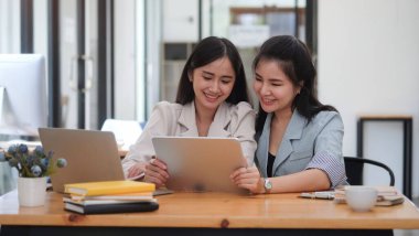 Happy business woman using stylus pen writing some information on digital tablet.	