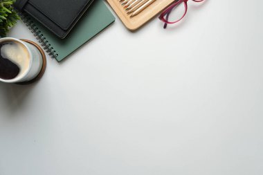 Not defteri, kahve fincanı ve gözlüklü beyaz ofis masası. Metin için alanı kopyala.